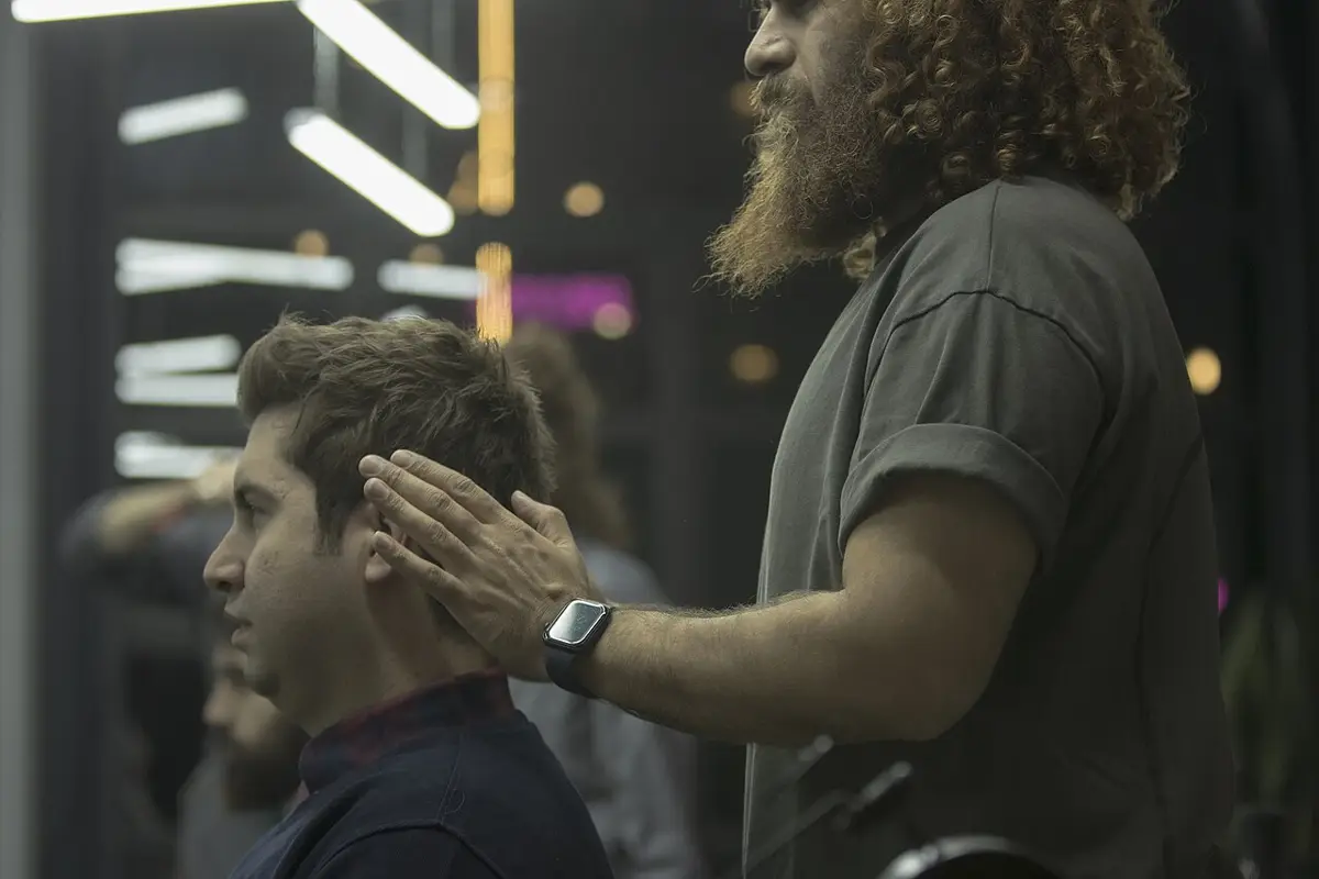 Peluquero cortando el pelo a un cliente en un salón