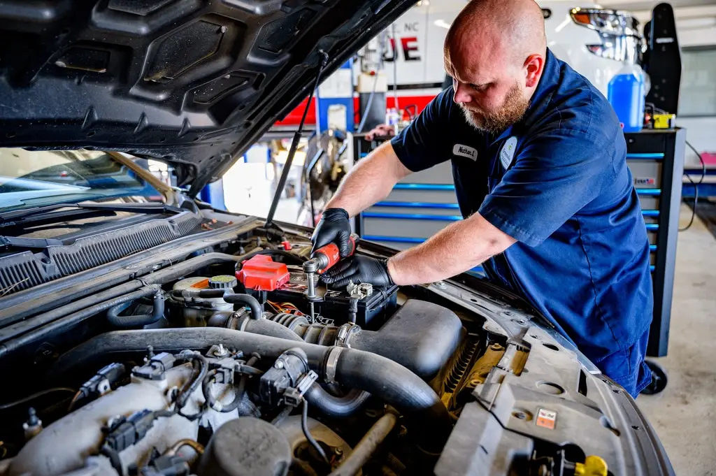Mecánico revisando el motor de un coche en un taller
